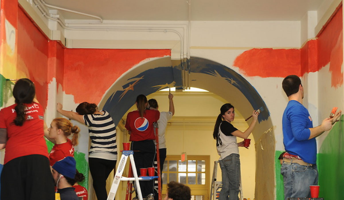 Catholic University students painting a hallway
