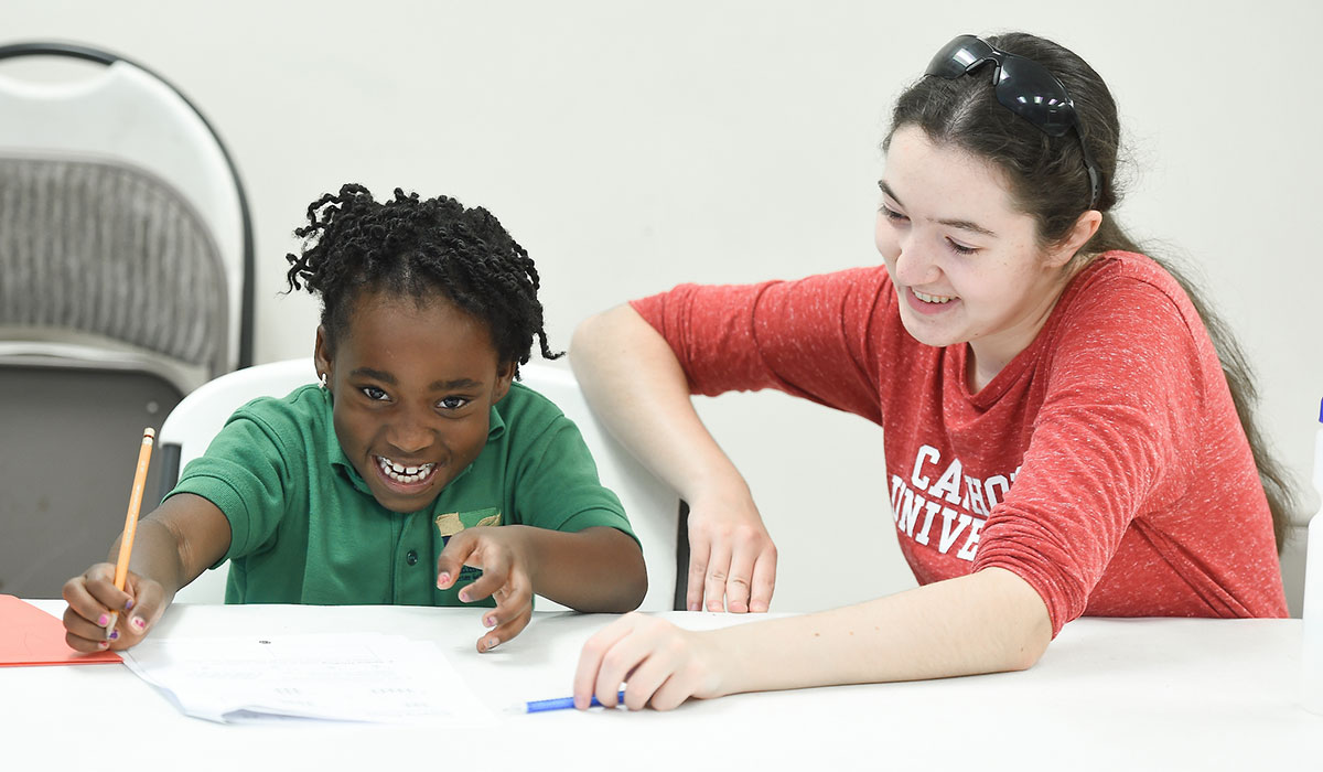 Student helping child with homework