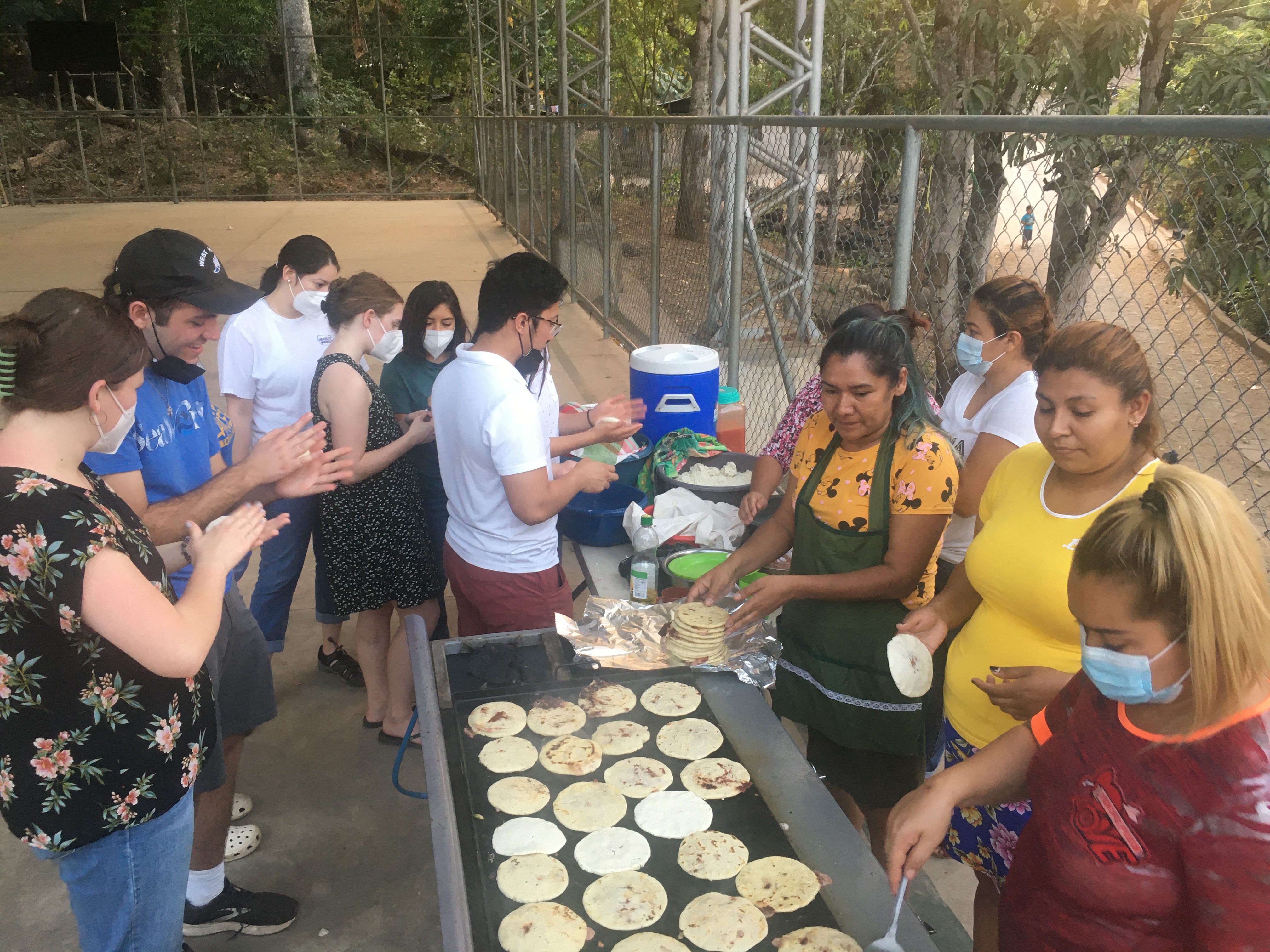 Shot of students and local women making pupusas