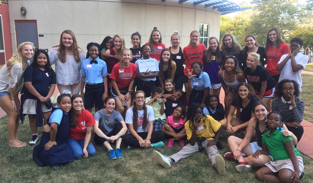 Students posing with members of Girls in Action