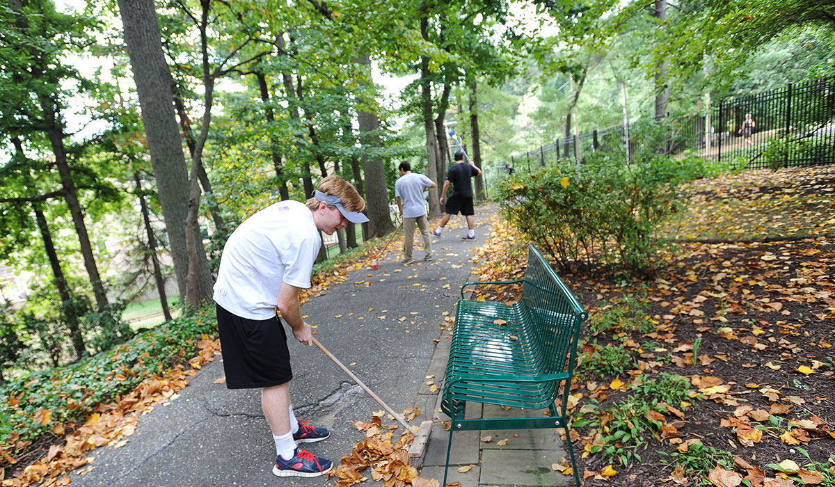 Catholic University student raking leaves 